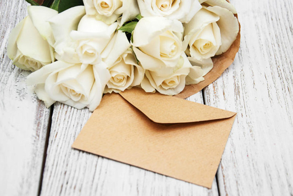 A bouquet of white roses and an envelope.